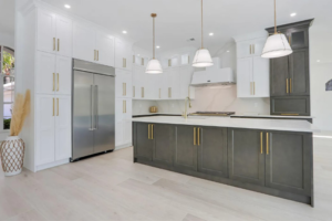 Transitional kitchen with white and gray cabinets, pendant lighting, and large island.