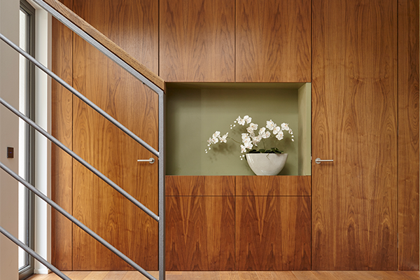 Wood-paneled staircase with built-in storage and vertical design detail.