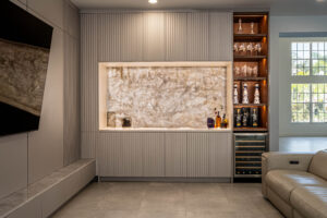 Custom bar cabinetry with illuminated onyx backsplash and floating shelves.