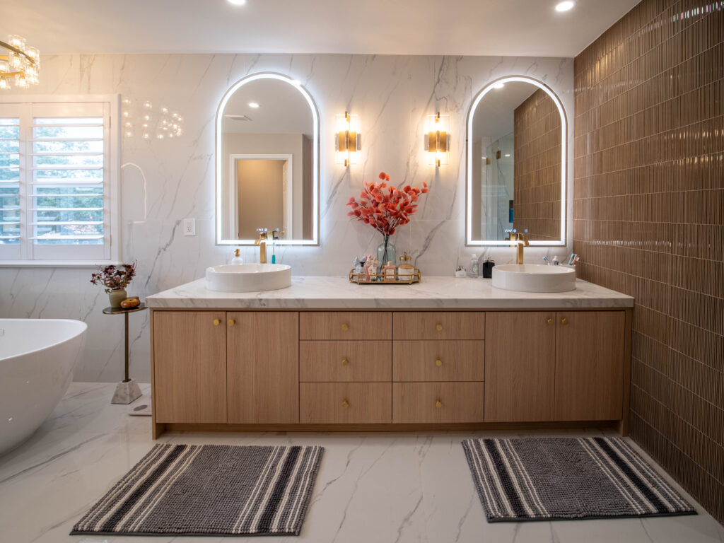 Custom bathroom design in Port St. Lucie by Mahogany Kitchens. Master bathroom with dual vanity, wood drawers, and arched mirrors.