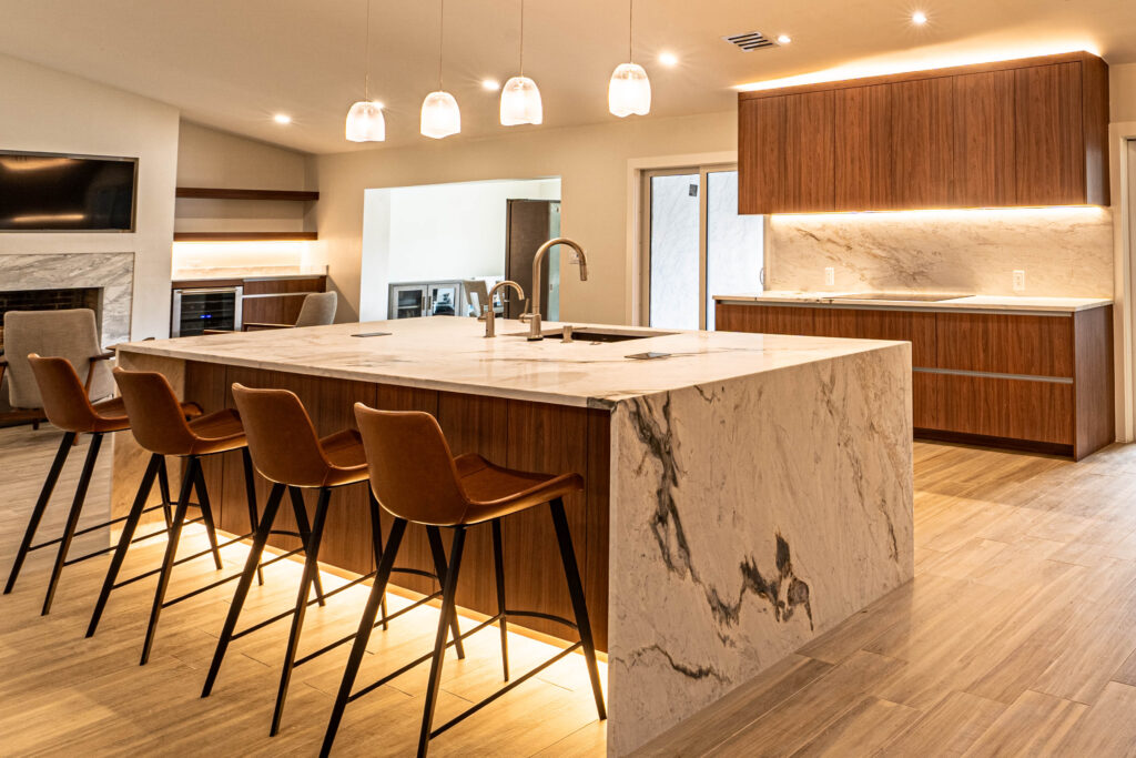 Contemporary kitchen with waterfall marble island, pendant lights, and warm wood tones.