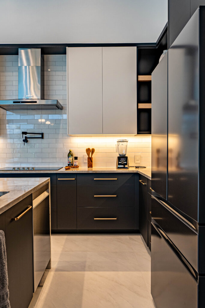 White U-shaped kitchen with stainless steel appliances and tile flooring.