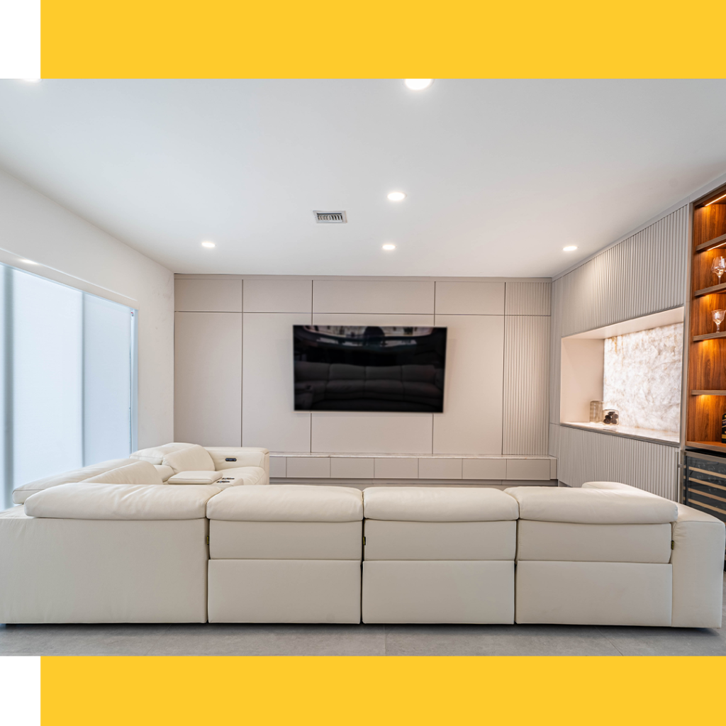 Contemporary living room with white sectional sofa and wall-mounted flat-screen TV.