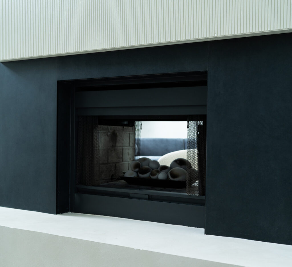 Modern black fireplace insert with smooth white frame and clean lines.
