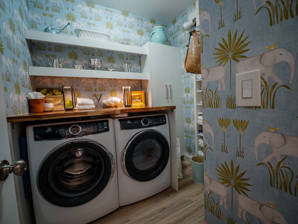 Laundry room with custom shelving and whimsical wallpaper.