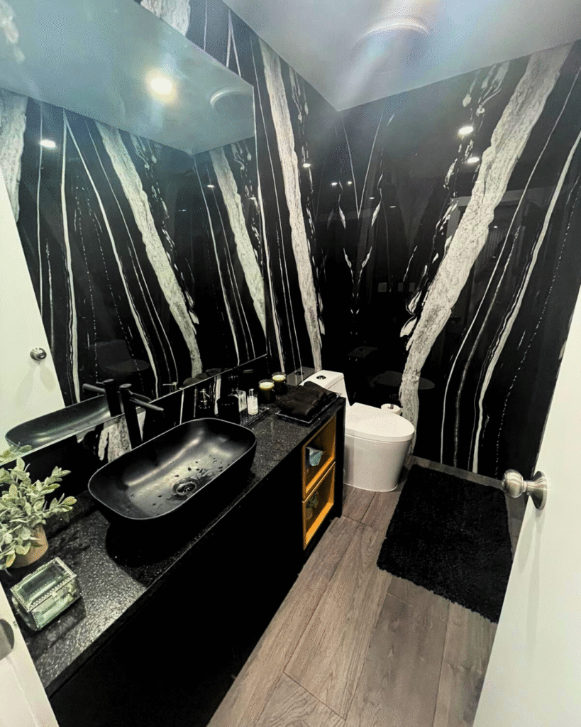Contemporary custom powder room with black floating vanity, black vessel sink, and striking black marble walls with white veining.